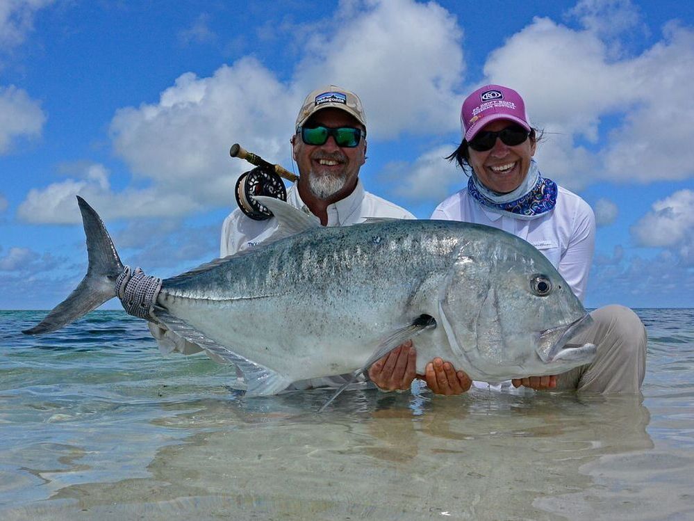 Fly fishing angler and guide with Giant Trevally