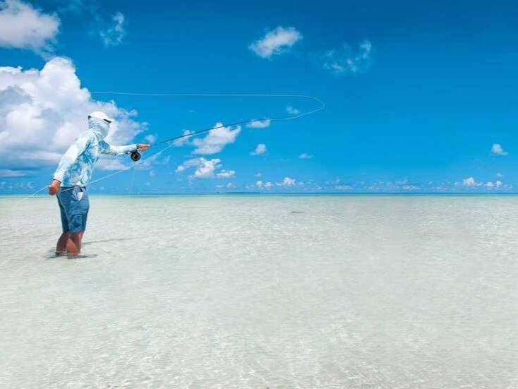 Fly fishing angler casting on the Seychelles flats