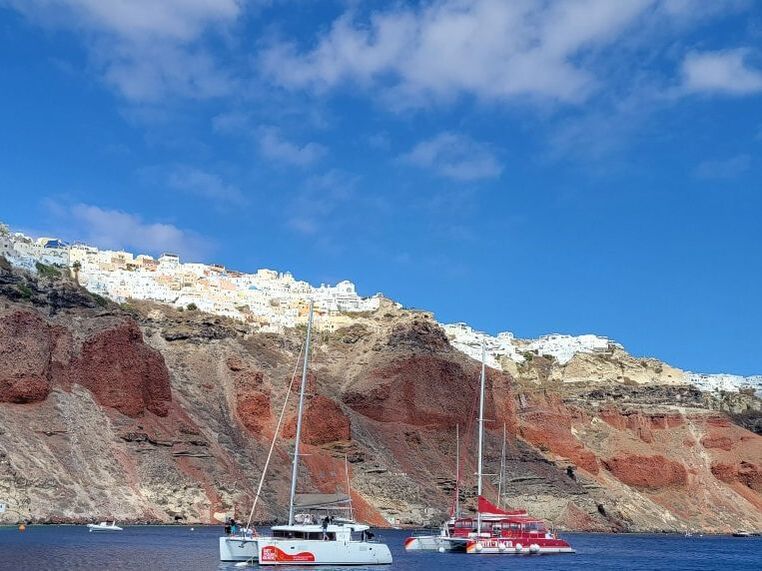 Santorini Greece red cliffs sailboats